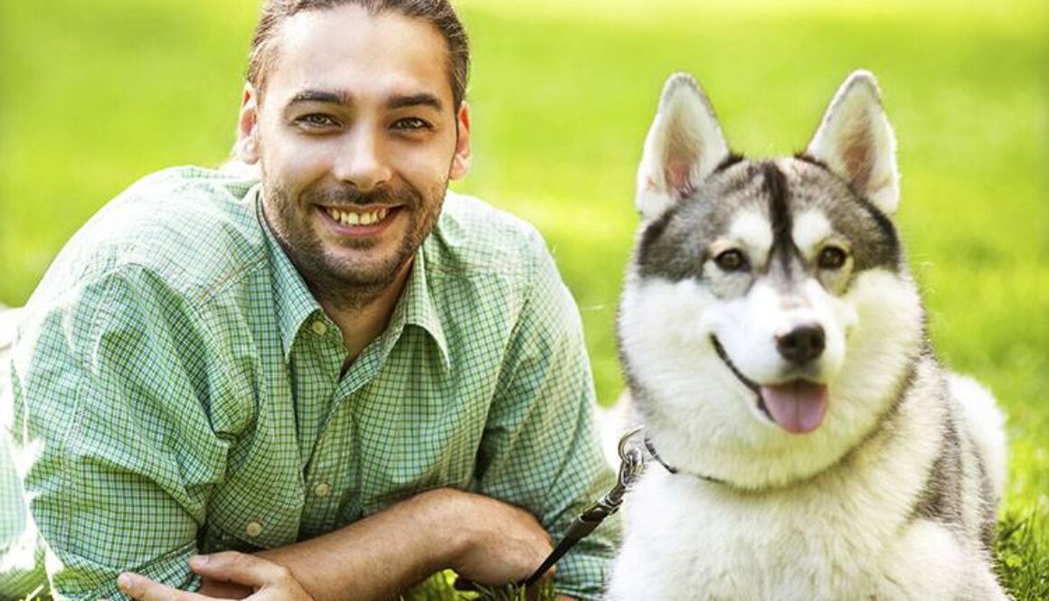 Man and Husky dog walk in the park.